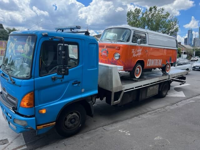 A combi van is getting towed on the back of a tow truck near Lalor.