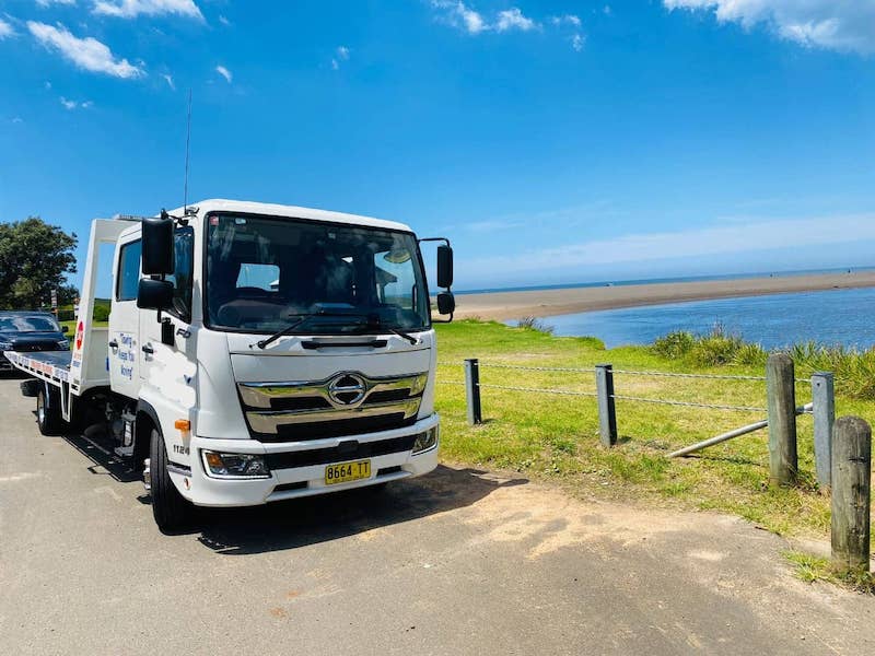 A tow truck near a beach is ready for service 24 hours a day.