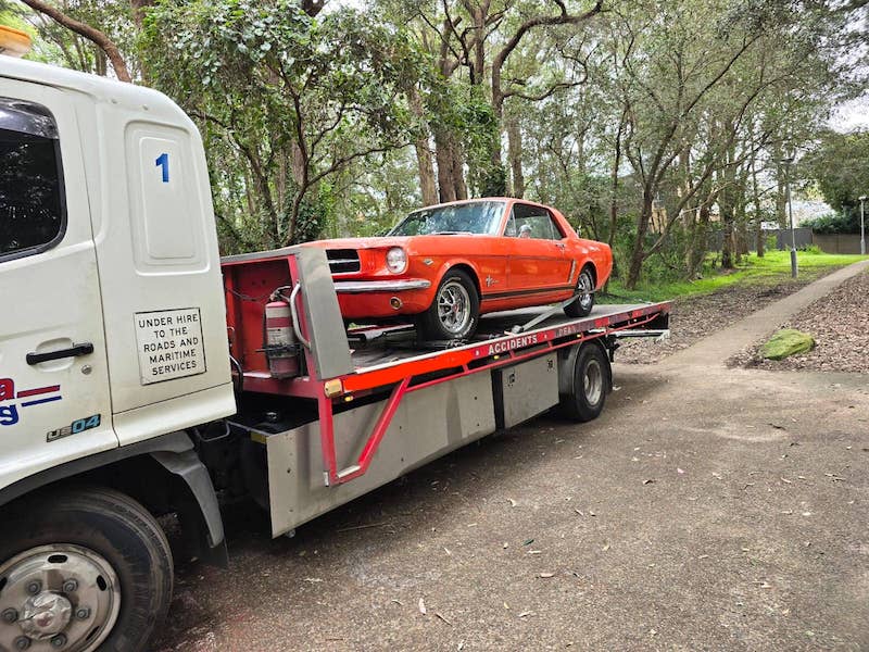 A classic car being towed a long distance by fast lalor towing.